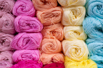 Multi-colored pink, whire, yellow, blue, white woolen threads in balls for knitting and handmade.