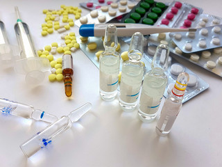 Pharmaceuticals. Antibiotics, various pills, syringes, ampoules on a white background.