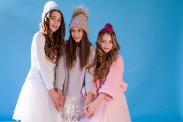 Three beautiful fun fashionable girls in winter snow hats