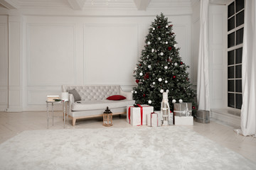 Christmas decoration. Gift boxes under Christmas tree. New Year decor in beautiful modern apartment.