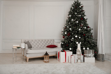 Christmas decoration. Gift boxes under Christmas tree. New Year decor in beautiful modern apartment.