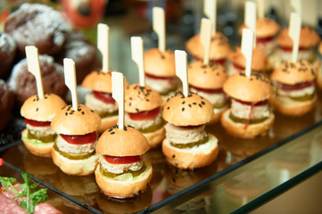 Set of mini burgers on a decorated table.