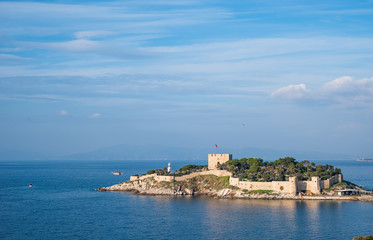 Fototapeta na wymiar Guvercinada located in Kusadasi. There is also a castle on the island which is built in a position protecting the harbor at the mouth of Kuşadası Gulf. High resolution photo for holiday themed works.