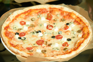 Pizza with olives, tomatoes and cheese.