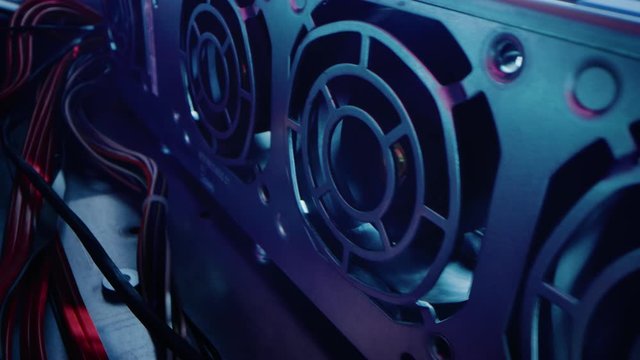 Close-up Macro Shot: Inside of the Computer Case. Camera Moves Alongside Row of Cooling Fans, with Multiple Power Cables Connected. Electronics Device Insides. Stylish Neon, Black, Pink, Blue Colors