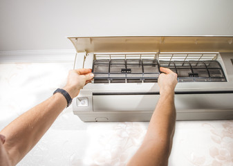 Close-up outdoor air condition unit with clogged obstructed compressor radiator grill. Details of...