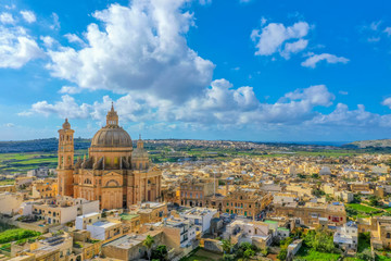 Fototapeta na wymiar Aerial view oа St. John Baptist Church. Countryside of Gozo island, cloudy blue sky. Malta island 