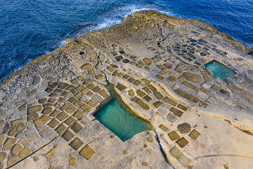 Salt pans on Gozo island. Blue sea and rocks. Malta island