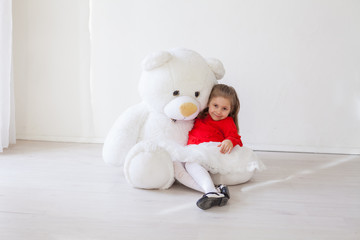 Beautiful little girl with big soft bear toy