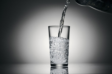 pouring sparkling water in a glass on a dark background