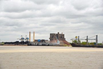Fototapeta premium A freighter sits by a sugar factory on the Mississippi River waiting to be loaded