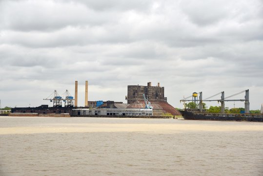 A freighter sits by a sugar factory on the Mississippi River waiting to be loaded