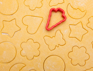 raw dough with cookie shapes with red tree