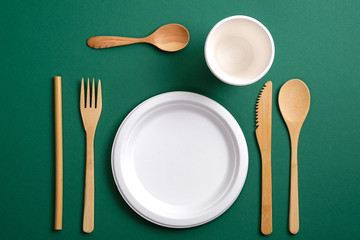 Set of Eco friendly bamboo cutlery on green background. Flat lay composition with reusable...