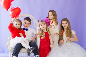 Children with red heart-shaped balloons at the holiday