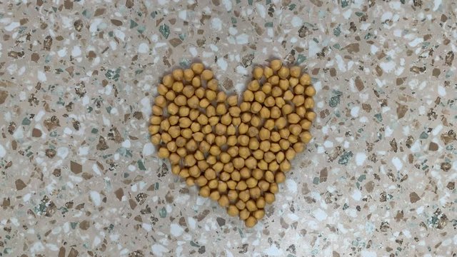 A chickpea heart grows and pulsates. Healthy eating concept. Stop motion, top view.