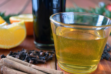 Glintwein of red wine with: orange, cinnamon, pepper, cloves and honey on a wooden background