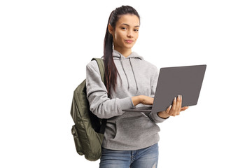 Cute female student holding a typing on a laptop and looking at the camera - obrazy, fototapety, plakaty