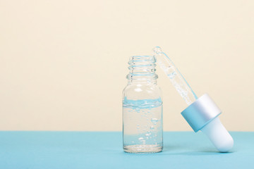 Face serum close-up on the trendy mint background. Collagen, hyaluronic acid for skin care. Achievements of modern science in cosmetic to preserve beauty. Copy space.