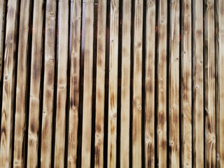 Wooden thin slats with traces of firing. Thin vertical slats.Wooden background.