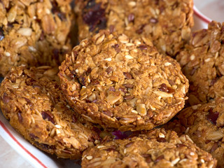 Healthy snack Close up whole grain cookies on white plate. Seeds and dried fruits. Vegetarian food and lifestyle concept