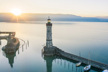 Atmospheric, high-angle view of Lindau Harbour lighthouse at sunrise, Lake Constance, Bavaria, Germany - obrazy, fototapety, plakaty
