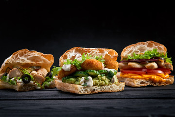 Closeup three different Appetizing sandwiches or burgers on wooden background