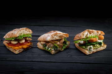 Closeup three different Appetizing sandwiches or burgers on wooden background