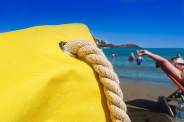 Close up of a yellow  beach bag on the beach