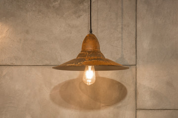 Loft industrial wire pendant vintage lamp against concrete wall