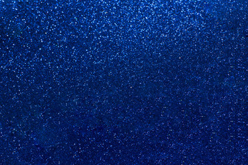Blue glowing dynamic festive background shining sparkles bokeh. Glitter texture, holidays concept. Trend color 2020, layout for design. Trendy color concept of year, classic blue background.