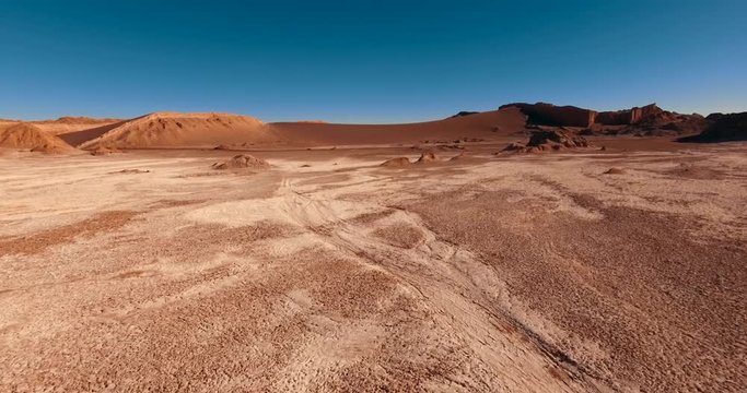 Valle de la Luna. The place to visit in Chile at the west of San Pedro De Atacama. Extremely dry, lifeless terrain of terracotta color all around. The clear blue sky over the landscape. Aerial. 4K