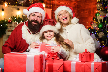Obraz na płótnie Canvas Happy New Year. Winter holidays. Shopping sales. merry christmas. Father and mother love daughter. small child and parents in santa hat. xmas gift boxes. Open present. Happy family celebrate new year