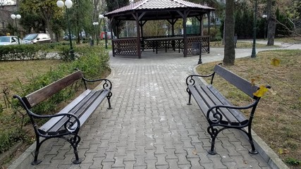 two dark wood benches and gazebo
