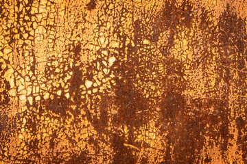 background of a yellow peeling paint on a rusty metallic surface