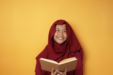 Muslim Teenage Girl Reading Book and Thinking, Happy Smiling Expression