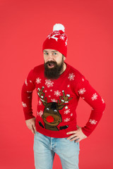 Happy new year concept. Join holiday party. Christmas eve. Winter outfit. Good vibes. Favorite winter season indoor activities. Hipster bearded man wear winter sweater and hat red background