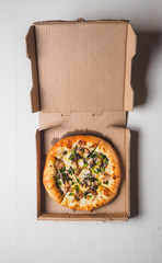 Pizza pizzetta in cardboard delivery box on white background