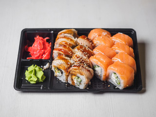 Japanese food sushi roll with raw fish and rice. delivery plastic boxes