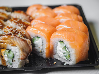 Japanese food sushi roll with raw fish and rice. delivery plastic boxes