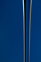 A vertical stream of water on a blue background in close-up. Abstraction.