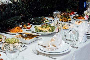 Beautifully served banquet table with cold, hot appetizers. Holiday table with various dishes, snacks, drinks. View from the top. 