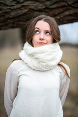 Emotion photo. Young cute white caucasian teen girl with cat eyes in white scarf in cold autumn...