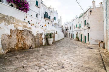 A public street with traditional houses in the old town area of the city center in Ostuni, South...