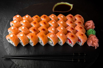 Sushi set with fresh ingredients on black background. Different types of philadelphia. Sushi menu. Japanese food. 