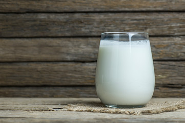 Glass cup of Turkish traditional drink ayran , kefir or buttermilk made from yogurt, on wooden rustic background, healthy food