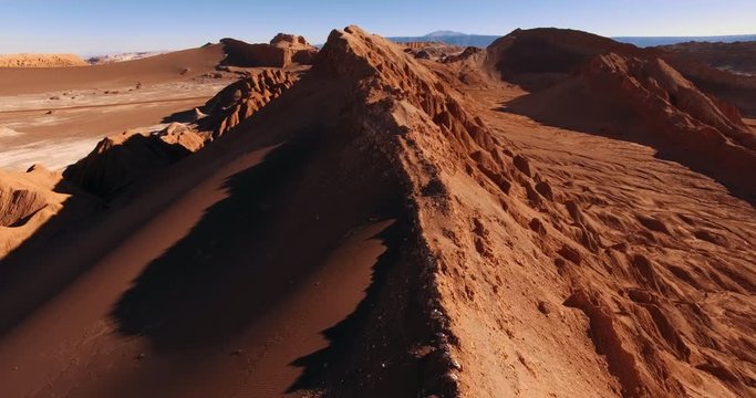 The flight over the dune ridge in Moon Valley. Fantastic landscape of Atacama desert. Panoramic view of vast arid terrain and erosion formations. San Pedro de Atacama. Chile. Aerial. 4K