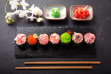 Gunkan sushi set with salmon, tuna, perch, eel, scallop, caviar, shrimp, sharp.  Traditional Japanese cuisine. Black background. Beautiful geometric style food