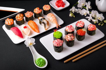 Gunkan sushi set with salmon, tuna, perch, eel, scallop, caviar, shrimp, sharp.  Traditional Japanese cuisine. Black background. Beautiful geometric style food