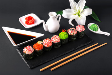 Gunkan sushi set with salmon, tuna, perch, eel, scallop, caviar, shrimp, sharp.  Traditional Japanese cuisine. Black background. Beautiful geometric style food